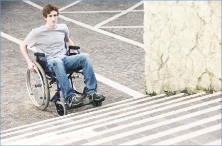 The photo shows a student in a wheelchair facing a set of stairs and looking concerned.