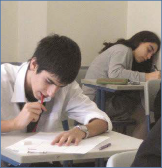 The photo shows students concentrating on an exam.