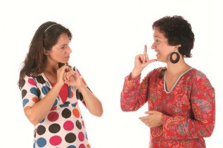 The photo shows two women who are communicating in sign language.